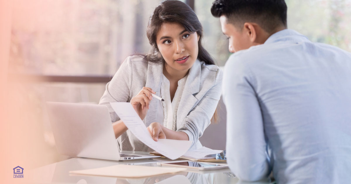 Homebuyers sitting with loan officer reviewing closing documents — 2025 USA